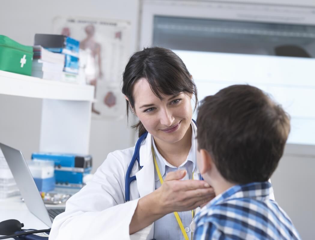 Endokrynolog dziecięcy bada chłopca w gabinecie lekarskim.