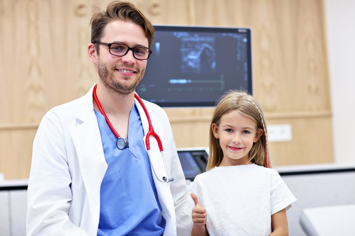 Lekarz w gabinecie to urolog dziecięcy razem z młodą pacjentką.